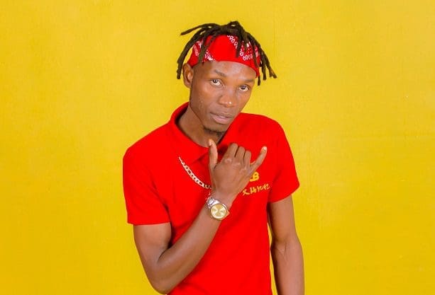 Kaira-Smacks.jpg Man wearing a red bandana, red polo shirt, and a gold chain, posed against a yellow background, radiating charisma reminiscent of emerging music industry talent like Smacks Kayira.