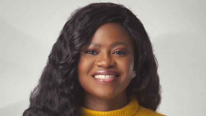 Director-for-Artist-and-Media-Relations-at-Boomplay-Tosin-Sorinola-e1669917483817.jpg A person with long, wavy dark hair, smiling and wearing a yellow sweater, stands against a light gray background. Boasting an affinity for Boomplay and Generations Radio, their passion for the music business is unmistakable.