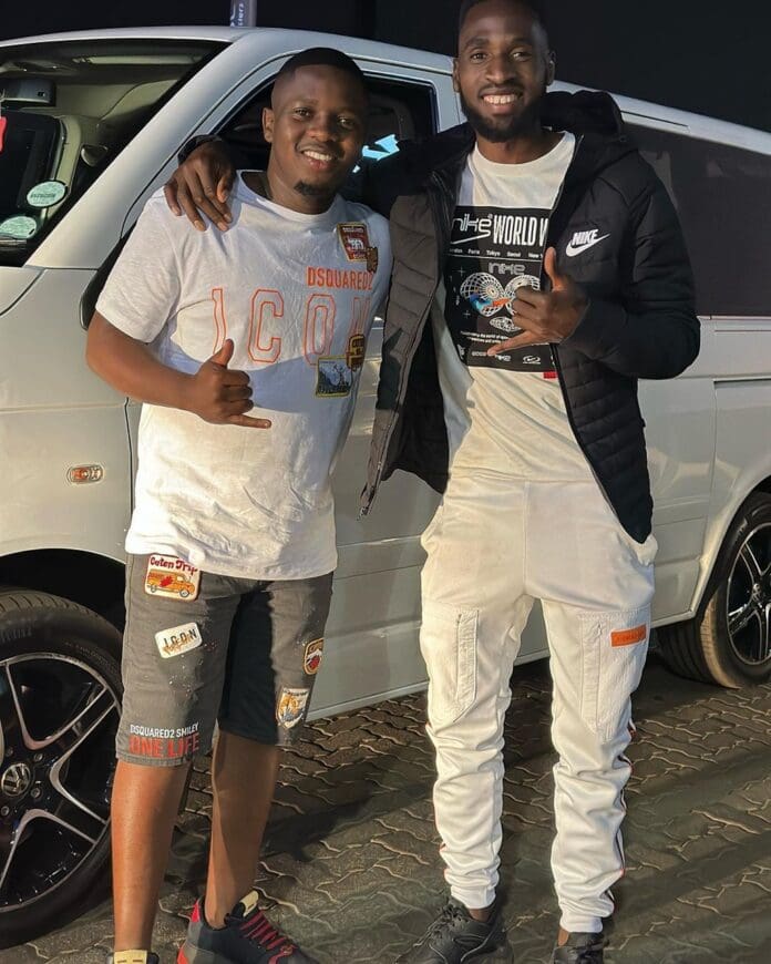 Two men standing next to a van. Two men standing next to a van.