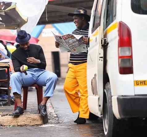 Two men sitting on a bench next to a van while reconciling differences and preparing to release "Maba Jabul'Abantu Vol. 2". Two men sitting on a bench next to a van while reconciling differences and preparing to release "Maba Jabul'Abantu Vol. 2".