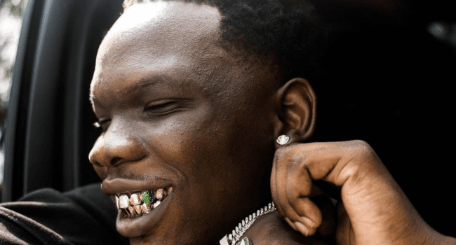 A man in a car wearing a "Yena Yedwa" neckchain. A man in a car wearing a "Yena Yedwa" neckchain.