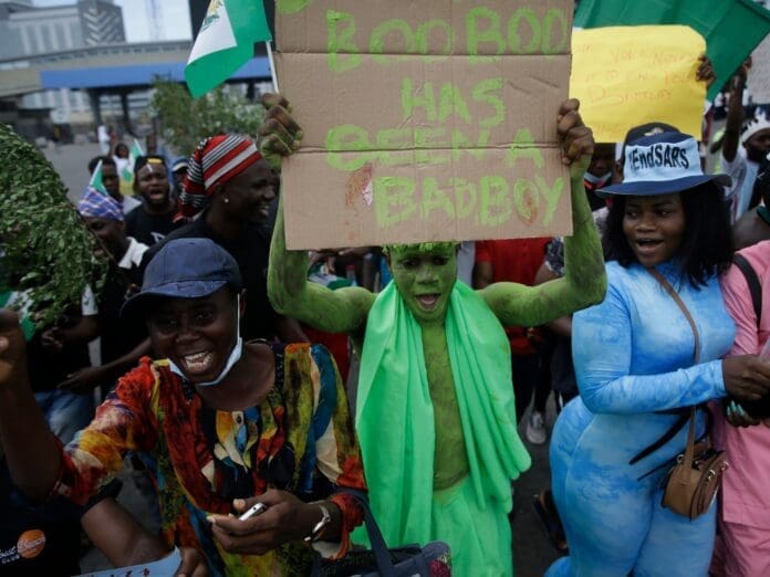 A group of people holding signs in front of a building in Nigeria. A group of people holding signs in front of a building in Nigeria.