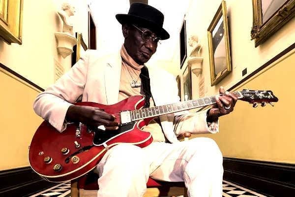 A musician playing a red guitar. A musician playing a red guitar.
