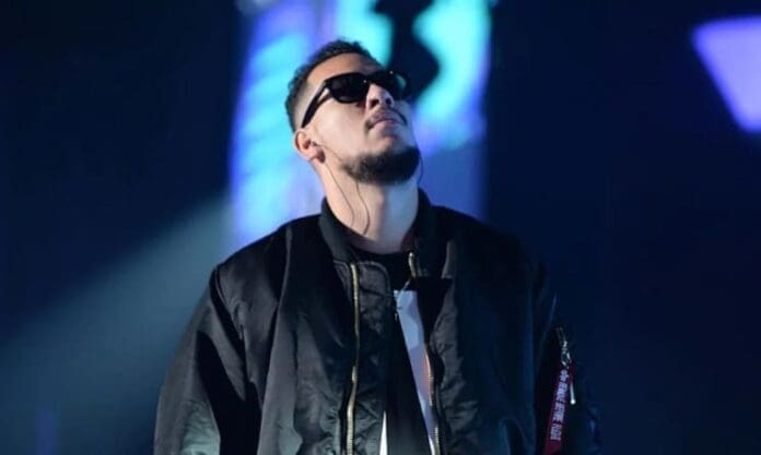 A man in a black jacket is standing on stage at the South African Music Awards 2023. A man in a black jacket is standing on stage at the South African Music Awards 2023.