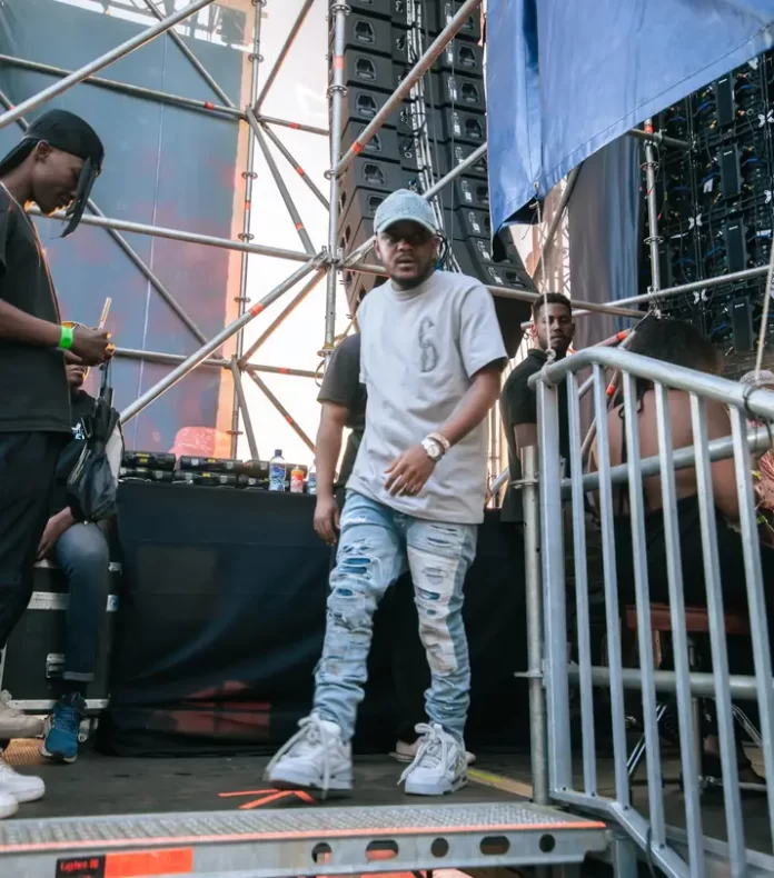 A man is performing on stage at a music festival. A man is performing on stage at a music festival.