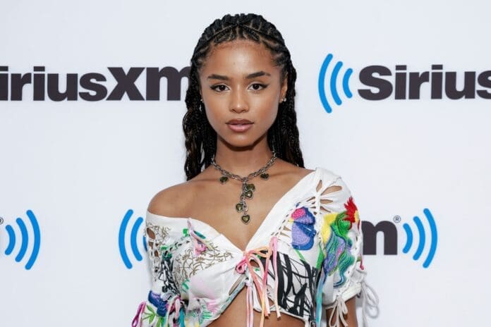 A black woman in a floral crop top poses on the red carpet. A black woman in a floral crop top poses on the red carpet.