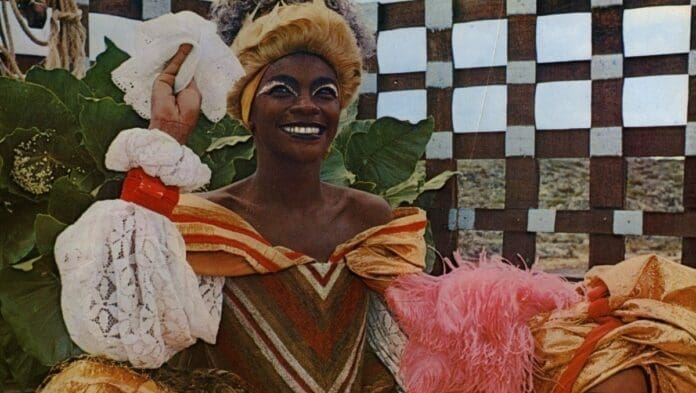 Xica da Silva, a Brazilian freedwoman, captivatingly dons an elegant costume while gracefully holding a flower. Xica da Silva, a Brazilian freedwoman, captivatingly dons an elegant costume while gracefully holding a flower.