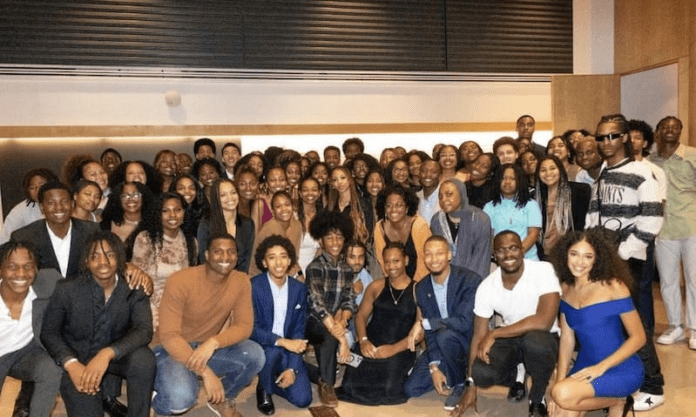 A group of Generational people posing for a photo in a room. A group of Generational people posing for a photo in a room.