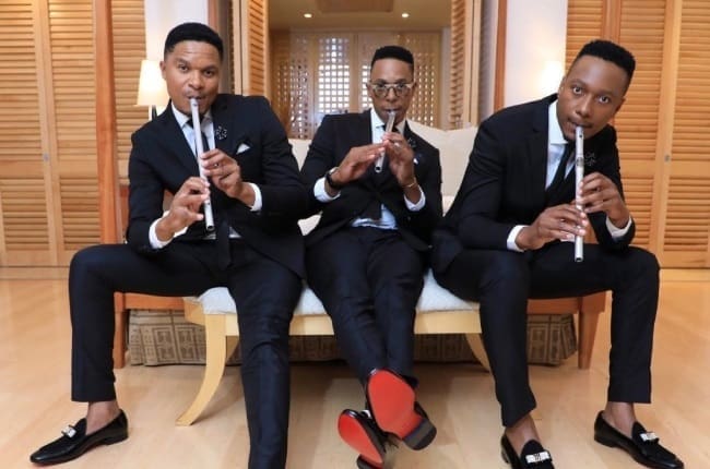 Kwela Tebza, a pennywhistle-playing foursome, sitting on a couch playing flutes. Kwela Tebza, a pennywhistle-playing foursome, sitting on a couch playing flutes.
