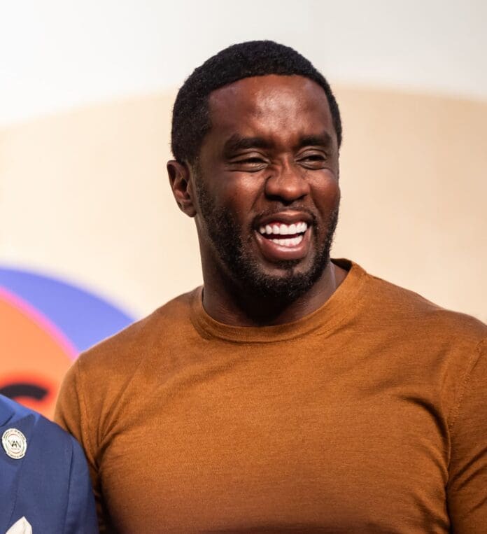 Two men, Diddy and another individual, smiling next to each other at an event. Two men, Diddy and another individual, smiling next to each other at an event.