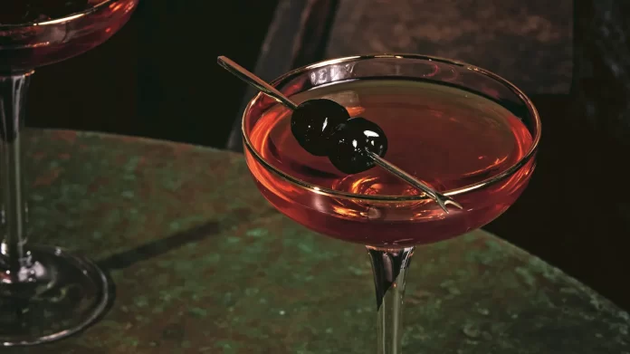 A mixology drink with an African American twist, featuring a martini garnished with a black olive on top. A mixology drink with an African American twist, featuring a martini garnished with a black olive on top.
