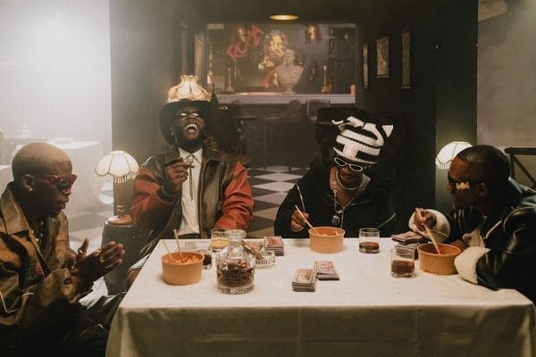 a-still-from-the-tshwala-bam-remix-video-showing-burna-boy-titom-yuppe-and-s-n-e-sitting-on-a-dinner-table.jpg