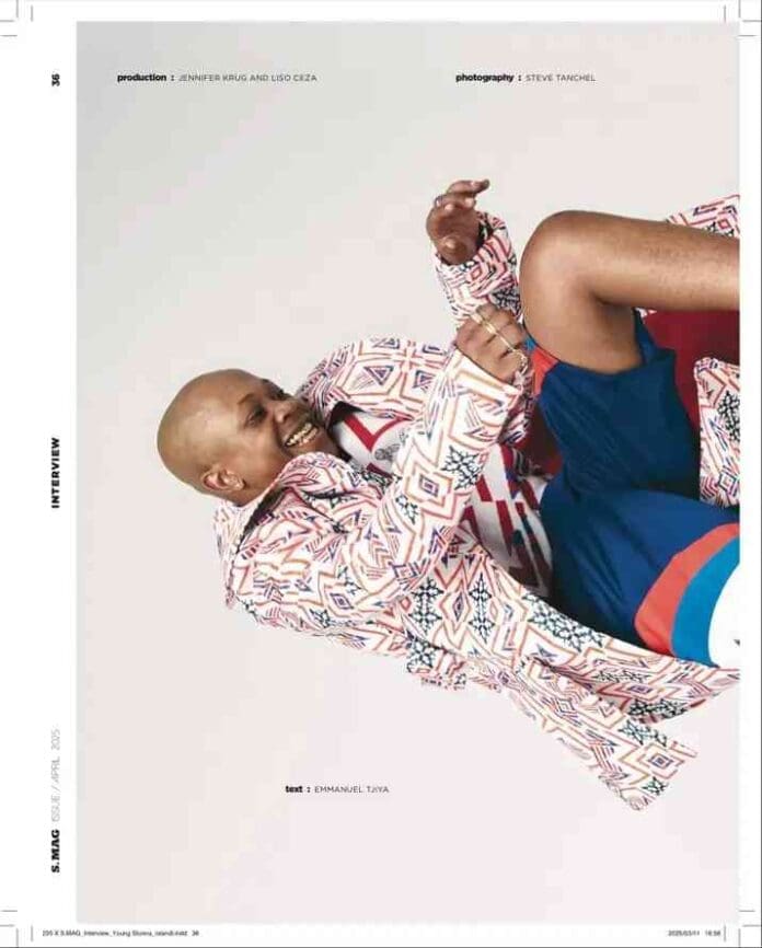 img_1_1746257858032.jpg A person in patterned outerwear and shorts reclines playfully against a white background, smiling and raising one arm, channeling the vibrant style of Young Stunna.