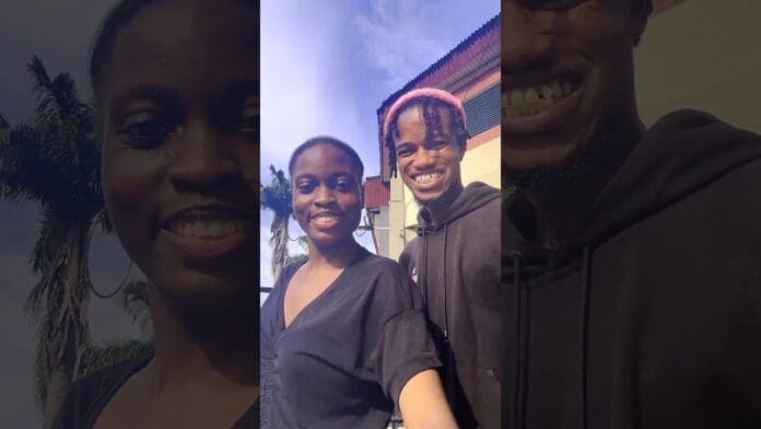 Two people smile outdoors in front of palm trees and a building under a blue sky, sharing their love for new music and afrobeats.