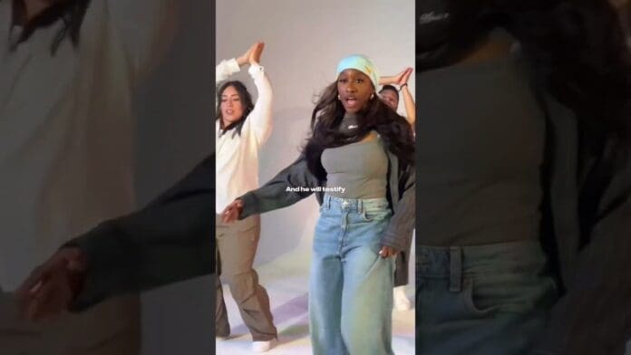 Three people are dancing indoors. The person in front wears a blue headscarf, gray top, black jacket, and jeans. Text on the image reads, "And he will testify." Featuring music by Naomi Raine and Annatoria, enjoy this Original vs Remix moment.