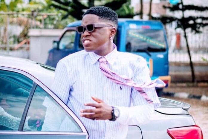 A person in sunglasses and a striped shirt stands near a car, their tie blown to the side by the wind—looking every bit like a musician on Ofego, the exclusive music streaming app.