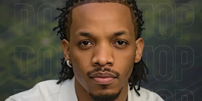 A man with short dreadlocks and facial hair looks directly at the camera, wearing a light-colored shirt and an earring, echoing the confident vibe of Tekno’s new single "Don't Stop," with a blurred background.