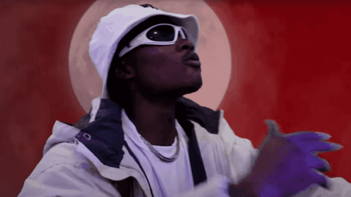 A person wearing a white bucket hat, white sunglasses, and a white jacket gestures with their hands in front of a red background with a large moon, capturing the bold style of Jay ERL from Bangers Only 5 on ghanamusic.com.