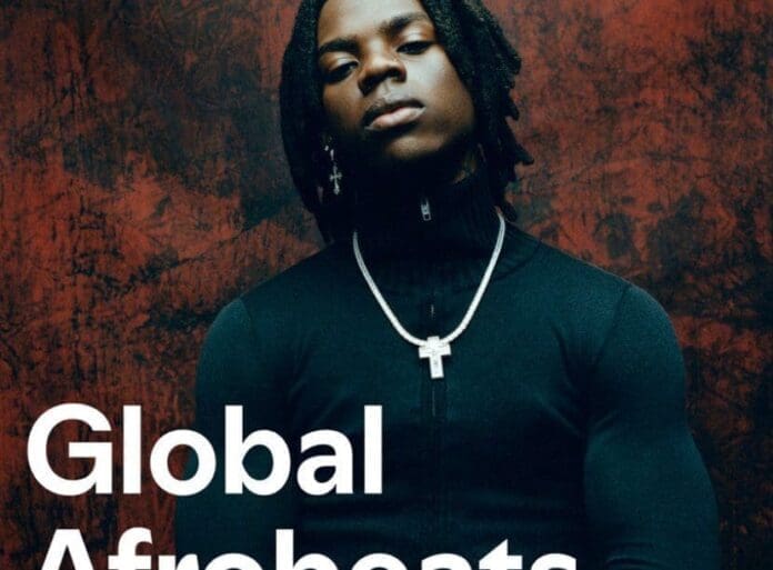 A person with medium-length braided hair wears a black long-sleeve top and a cross necklace, standing against a textured reddish-brown background. The text reads "Global Afrobeats"—a nod to the vibrant Afrobeats sound on Spotify.