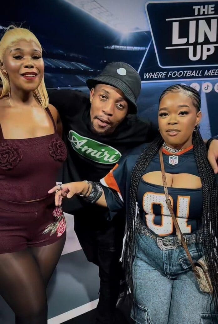 Three people pose together in front of a sports-themed backdrop; one wears a floral top, one a bucket hat and T-shirt, and the third a football jersey with jeans, celebrating Motsweding FM’s Shela Song of the Year.