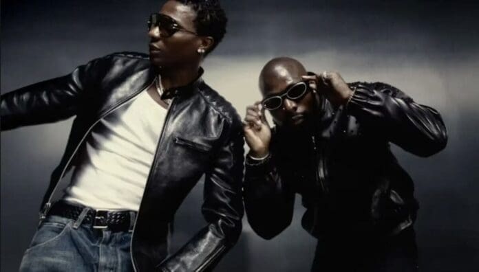 Two men wearing black leather jackets and sunglasses pose against a dark background, channeling the bold energy often seen in Top African Songs featured by OkayAfrica.