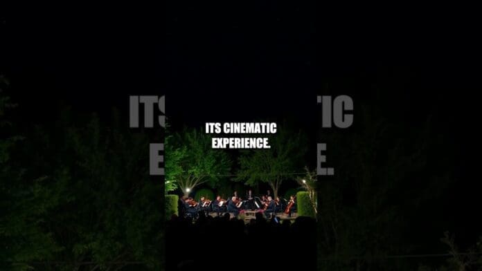 A string quartet of new artists performs outdoors at night, illuminated by stage lights, with the text "ITS CINEMATIC EXPERIENCE" above them.