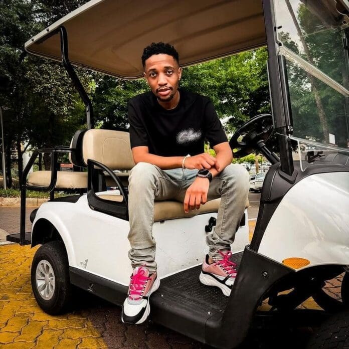 A man wearing a black t-shirt, jeans, and pink-laced sneakers sits on the edge of a white golf cart parked outdoors, enjoying amapiano beats on his phone.