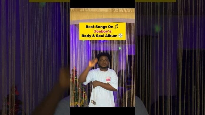 A man in a white t-shirt stands in front of beaded curtains and purple lights, gesturing with one hand. Text above reads: "Best Songs On Joeboy's New Album, Body & Soul.