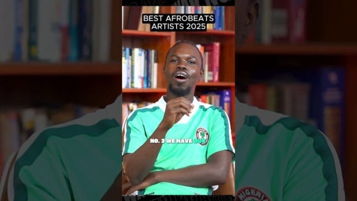 A man in a green Nigeria shirt sits in front of bookshelves with text above him that reads "Top 10 Afrobeats Artists 2025" and "No. 3: We have OLU.