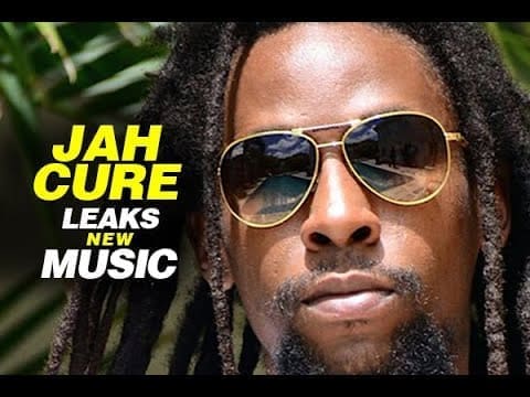 A man with long hair wearing sunglasses teases new music from JAH CURE.