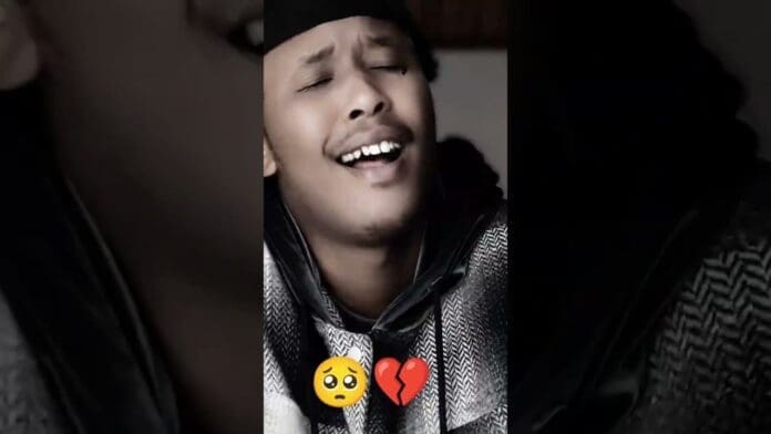 A person with closed eyes sings acapella, expressing deep emotion; a sad face and broken heart emoji are overlaid at the bottom of the image.
