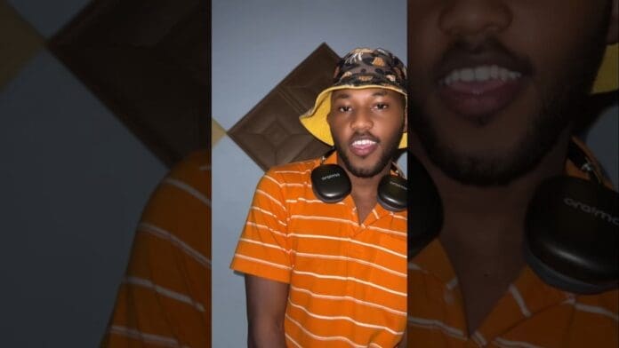 A person wearing an orange striped shirt and a patterned bucket hat poses indoors with headphones around their neck, ready to enjoy malawimusic or the latest afrobeats.