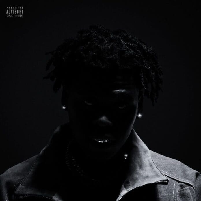 A person with dreadlocks is partially visible in low lighting, wearing a jacket and jewelry. The image is dark with a parental advisory label in the top left corner, hinting at Baby Tai's raw style and the mystique of Usimamane.