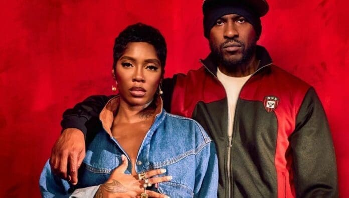 A woman in a denim jacket stands beside a man in a black and red jacket and beanie, his arm resting on her shoulder, both facing the camera against a red background—capturing the vibrant energy often found in African music.