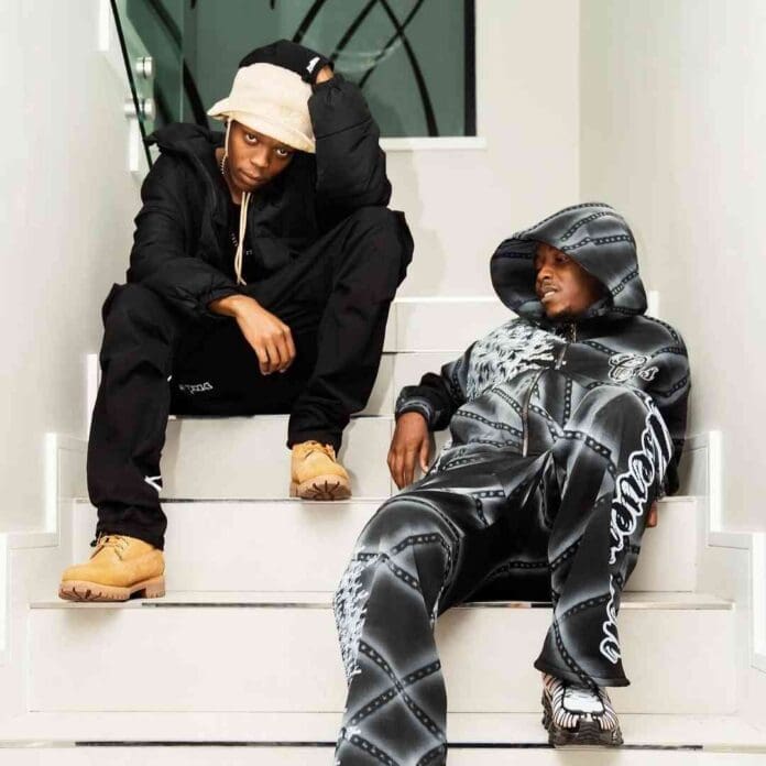 Two men, inspired by the laid-back vibes of Mellow & Sleezy, sit on stairs sharing laughs and YFM Club Y Mix tunes.