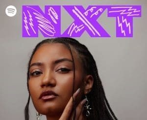 A woman with braided hair poses in front of a gray background, with "NXT" in bold purple letters and white patterns at the top. The Spotify logo and WETALKSOUND hint at fresh sounds from the Spotify NXT Playlist.