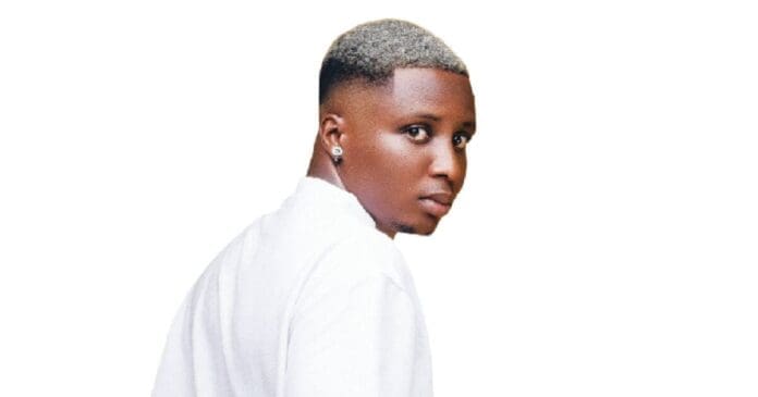 A person with short, light-colored hair, wearing a white shirt and an earring, channels global music stardom as they look over their shoulder against a white background.