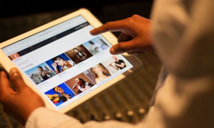 An intern explores the Music In Africa platform on a tablet, discovering resources valuable for arts administrators.