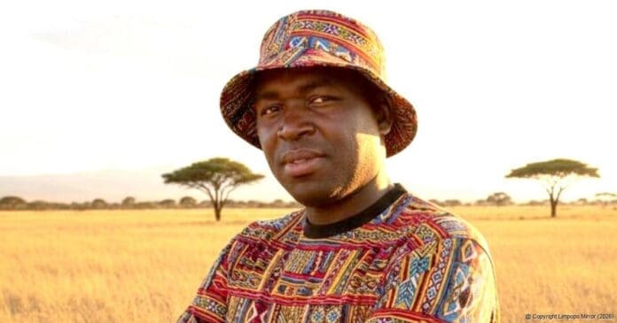A man wearing a colorful patterned shirt and hat stands in a grassy field with acacia trees in the background, capturing the lively spirit of Mabizana and its vibrant entertainment scene.