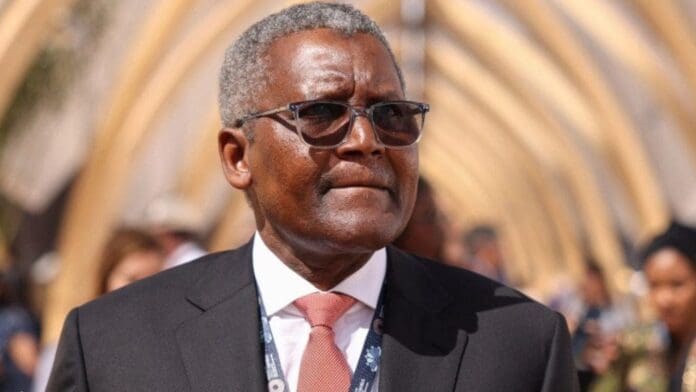 A man in a dark suit, white shirt, and pink tie wearing sunglasses stands outdoors under a geometric canopy structure, exuding the confidence found in Afrobeats lyrics—perfect for an editorial on unorthodoxreviews.com.