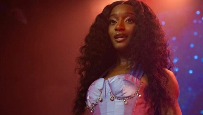 A woman with long hair wearing a purple dress, inspired by the vibrant styles of African artists featured on OkayAfrica.