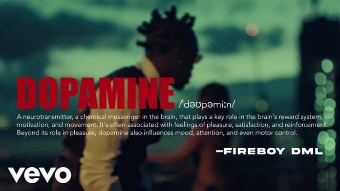 A man with braided hair stands in the foreground, city lights blurred behind him; bold text reads "DOPAMINE" with a definition and a quote from Fireboy DML, styled as part of the Official Visualizer.