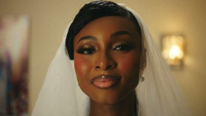 A woman wearing a white veil and formal makeup softly smiles at the camera, her RING visible, with a blurred indoor background—capturing the elegant mood of the SHODAY OFFICIAL MUSIC VIDEO.