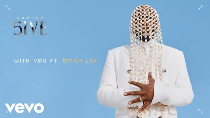 A person in a white suit poses against a blue background, their face hidden by hanging cowrie shells. Text reads "Davido 5IVE With You ft. Omah Lay" and "Vevo.