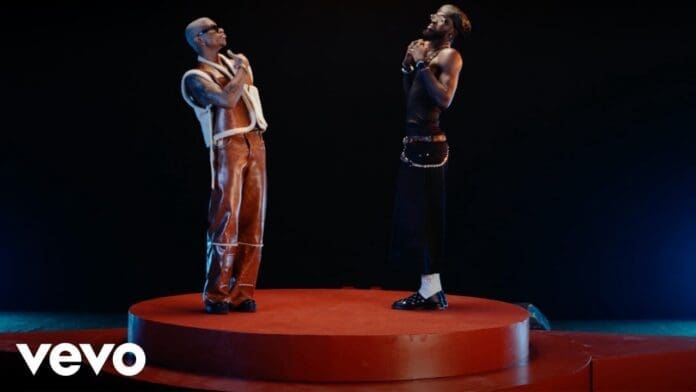 Two men, possibly KiDi and Black Sherif, stand facing each other on a circular red platform against a dark background, arms crossed over their chests. The Vevo logo is visible in the corner.