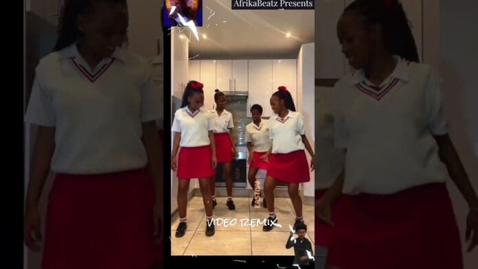 Four young women in matching white tops and red skirts perform a dance routine to amapiano beats in a kitchen, with a video remix banner overlay at the bottom of the image.