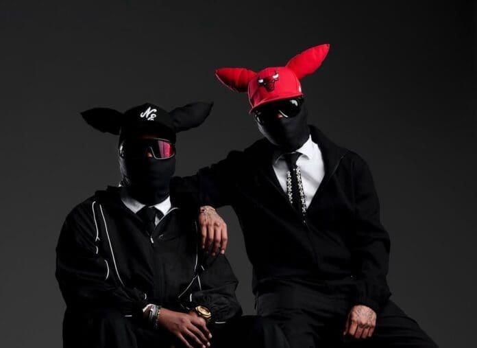 Two people channel the 2wobunnies vibe in black outfits, full face masks, sunglasses, and hats with large ears—one red with a bull logo, one black. Their look echoes the bold energy of Scotts Maphuma and Amapiano culture.