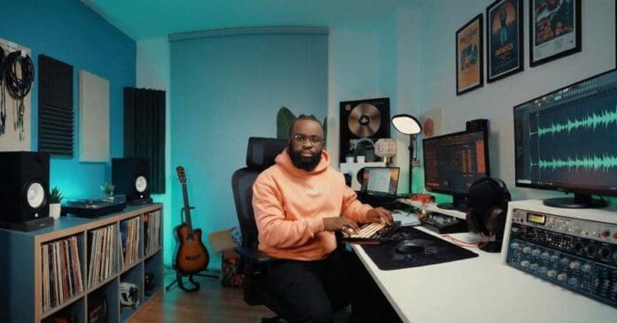 A man sits at a desk in a home music studio, surrounded by audio equipment, guitars, speakers, and vinyl records, fully immersed in his groove as waveforms dance across the computer screens.