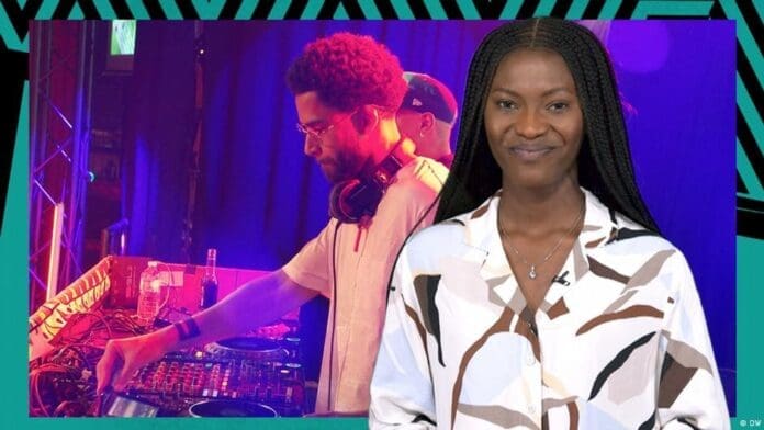 A woman stands in front of an image showing a DJ operating sound equipment at an event with colorful lighting, highlighting the vibrant energy of Afrobeats.