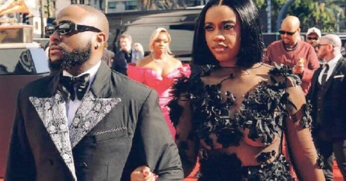 A man and woman walking on a red carpet at a Grammy event, showcasing Nigeria's Afrobeats elegance.